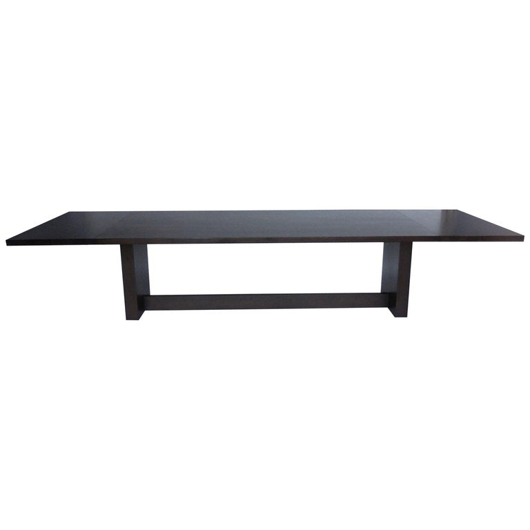Sleek modern walnut table with solid bases and trestle.